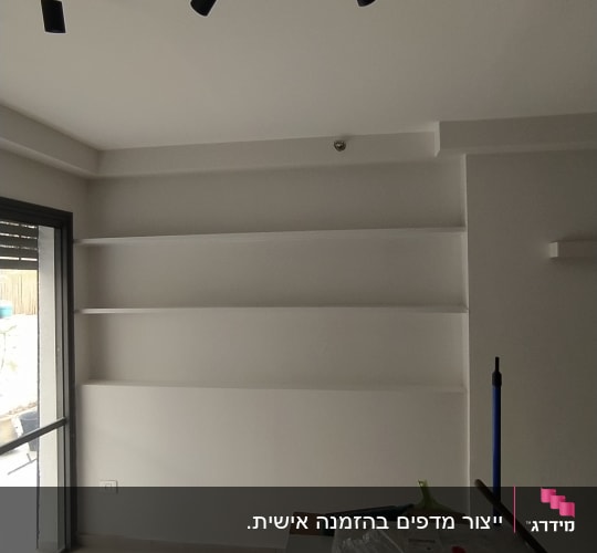 מדפים לבנים מותקנים על קיר